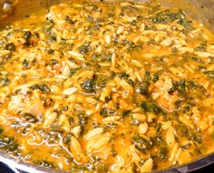 a pan filled with pasta and spinach covered in sauce