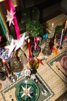 a table topped with candles and plates covered in stars