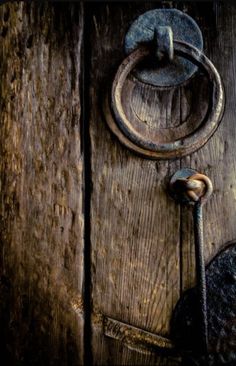 an old wooden door with a metal handle