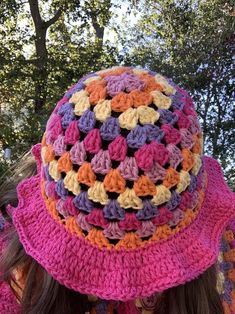 a close up of a person wearing a hat with crocheted flowers on it