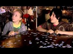 two people sitting at a table with puzzles on it