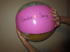 two hands holding up a pink ball with the words conduct and song written on it