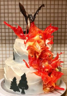 a white cake with red flowers and antlers on top