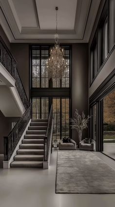 an elegant living room with chandelier and stairs leading up to the second floor