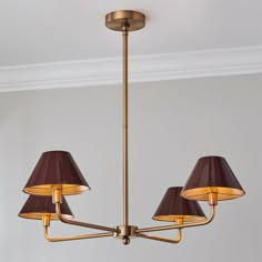 a chandelier with three lamps hanging from it's sides in a room