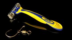 a yellow and blue razor sitting on top of a black surface