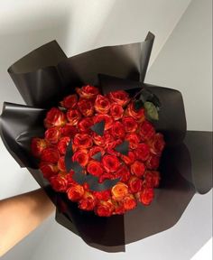 a person holding a bouquet of red roses with a smiley face drawn on the center