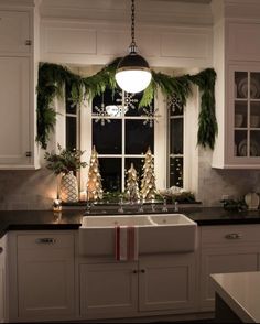 a kitchen decorated for christmas with evergreen garland