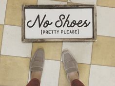 a person standing in front of a sign that says no shoes pretty please