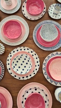 a table topped with lots of different colored plates and bowls covered in polka dot designs