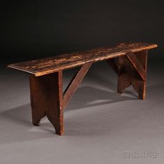 a wooden bench sitting on top of a gray floor