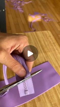 someone is cutting fabric with scissors on a table