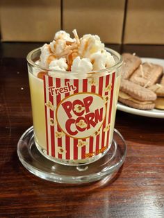 a cup filled with popcorn and marshmallows on top of a table