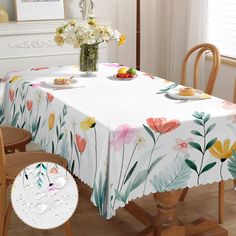 a table with flowers and plates on it in front of a white wall, next to a window