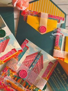 several different colored envelopes with designs on them and flowers in the middle one has a pink rose