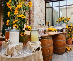 an outdoor bar with sunflowers and wine glasses