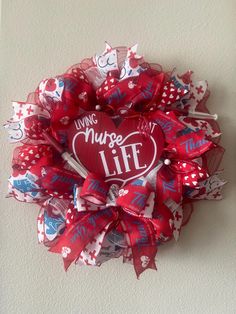 a red and white heart shaped wreath with writing on it