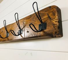 a wooden coat rack with three hooks on it