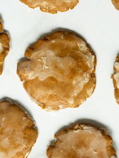 several cookies with icing sitting on top of a white surface