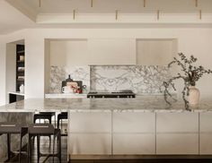 a kitchen with marble counter tops and bar stools