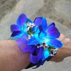 a person's arm with a blue flower on it and white flowers in the middle