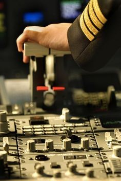 a close up of a person's hand on top of a control panel in a recording studio