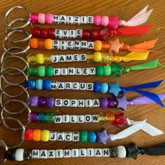 six personalized keychains with name tags attached to them on a wooden table