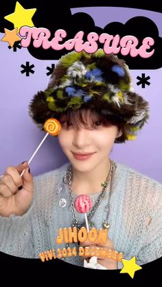 a person holding a lollipop in front of a purple wall with stars on it