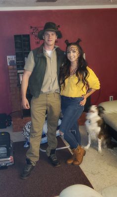 a man and woman standing next to each other in a living room with a dog