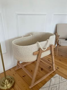 a baby crib sitting on top of a hard wood floor next to a chair