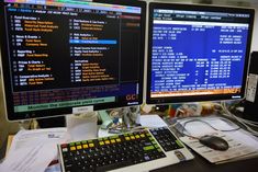 two computer monitors sitting next to each other on top of a desk in front of a keyboard and mouse