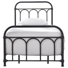 an iron bed frame with white sheets and pillows on the headboard, against a white background