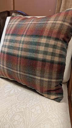 a plaid pillow sitting on top of a wooden chair