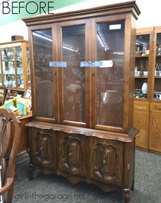 an old china cabinet with glass doors and wood trimming on the front, in a store