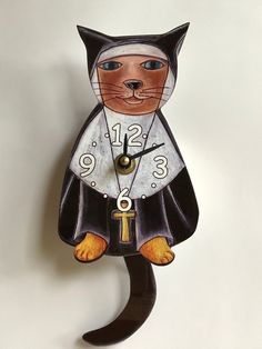 a clock with a cat on it's face is hanging from the side of a wall