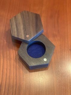 two wooden boxes sitting on top of a wooden table with one opening and the other closed