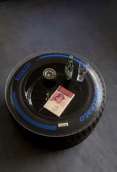 a black and blue tray with drinks on it that is sitting on the floor next to a book