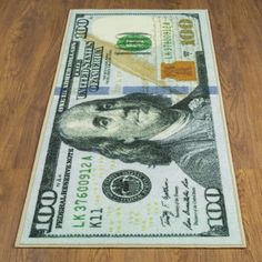 a dollar bill is on the floor in front of a wood floor with a rug