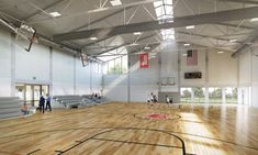 an indoor basketball court with benches and people playing on the hardwood floor in front of it