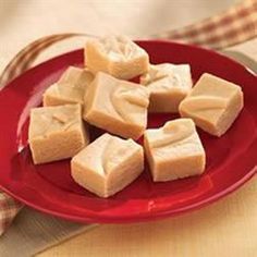 a red plate topped with cubes of fudge next to a fork and knife