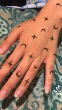 a woman's hand with stars and crescents tattooed on her left palm,