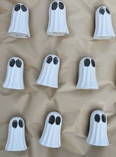 eight white plastic ghost decorations with black eyes