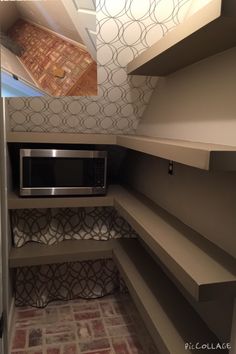 a microwave is sitting in the corner of a room that has shelves and shelving