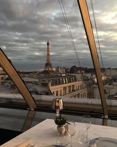 the table is set for two in front of the view of the eiffel tower