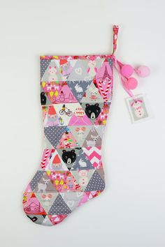 a christmas stocking with pink pom poms hanging from it's side