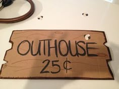 a sign that says outhouse 25 cents is on the table next to a pair of scissors