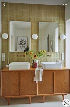 a bathroom with two sinks and mirrors on the wall