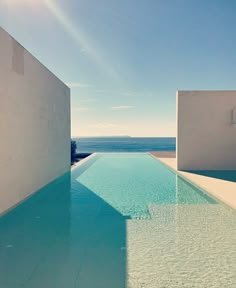 an empty swimming pool with the ocean in the background