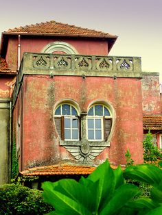 an old building with two windows on the top and one window in the middle that looks like a face