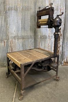 an old machine is sitting in front of a corrugated wall